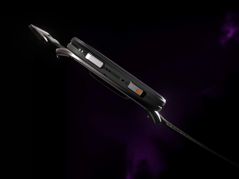 Smartwatch GARMIN Venu X1 Zbliżenie z boku na kopertę smartwatcha z widocznymi przyciskami w kolorze srebrnym i pomarańczowym na ciemnym tle.