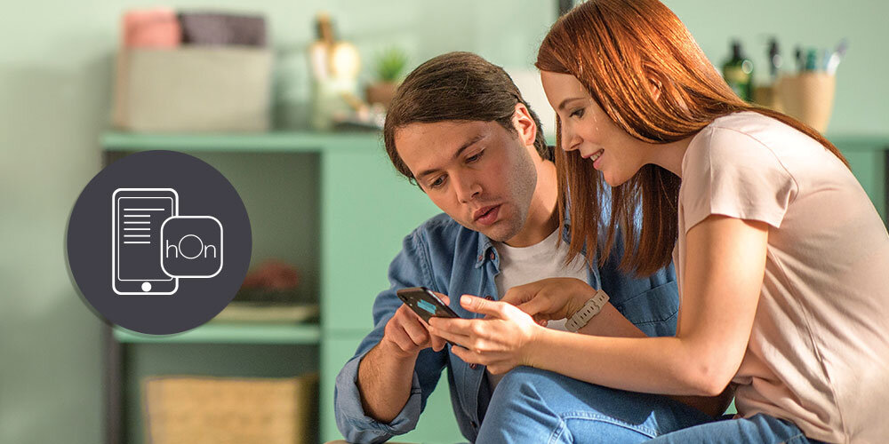 SUSZARKA CANDY AI PRODRY 700 BS H9N2B-S wizualizacja lifestyle kobieta mężczyzna smartfon w dłoni aplikacja hOn telefon Zdalne sterowanie suszarką 