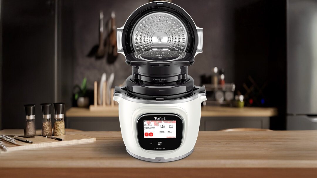Multicooker TEFAL Cook4Me Touch Pro jest otwarty na drewnianym blacie.