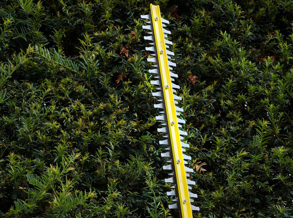 Nożyce do żywopłotu STANLEY Fatmax SFMCPH845B-XJ 450mm 18V akumulatorowe ściana żywopłotu zbliżenia na ostrze ostrze oparte o żywopłot faliste ostrze o długości 45 cm wykonane z hartowanej stali równe cięcie gałęzi o grubości do 19 mm skraca czas pracy ogranicza tępienie krawędzi