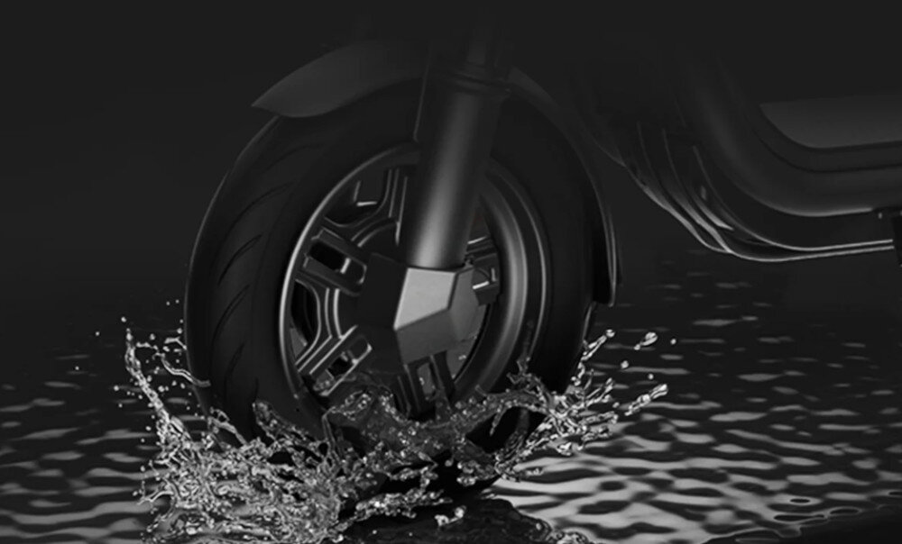 Hulajnoga elektryczna NAVEE V25i Pro 2 20km 300W 10 cali Czarny ciemne tło woda przednie koło lekko zanurzone w wodzie rozchlapuje wodę wokół klasa wodoodporności IPX5 odporność na strumienie wody o niskim ciśnieniu