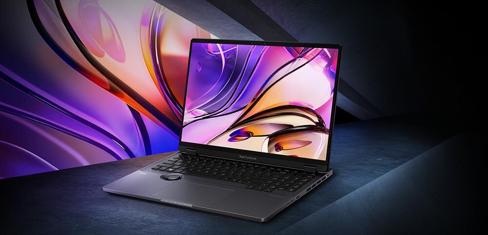 Laptop ASUS ProArt StudioBook H7604JI z otwartym ekranem wyświetlającym kolorową abstrakcyjną grafikę w odcieniach fioletu i różu na futurystycznym tle z efektami świetlnymi