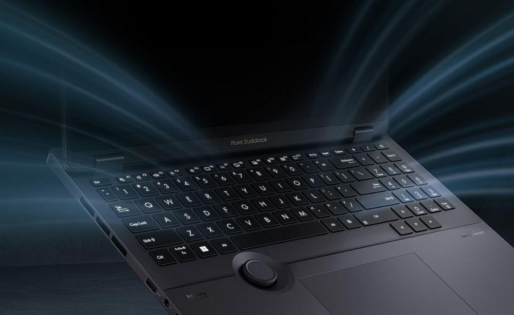 Klawiatura laptopa ASUS ProArt StudioBook z podświetleniem w kolorze niebieskim na ciemnym tle z efektami świetlnymi i promieniami światła wokół - Równomierne oświetlenie LED