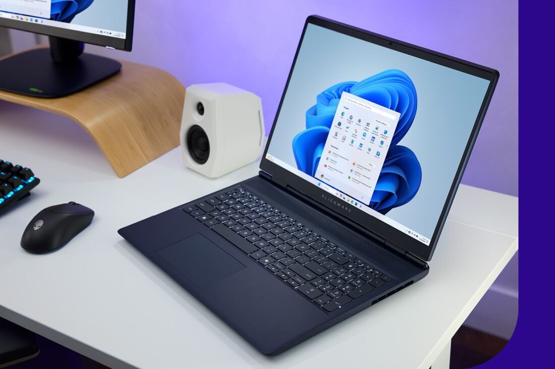 Laptop Dell Alienware 16 Aurora z systemem Windows 11 na ekranie w otoczeniu sprzętu gamingowego - System Windows 11