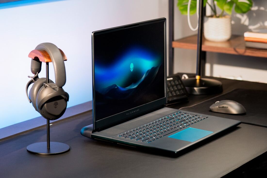 Dell Alienware 18 Area-51 na biurku z niebieskim podświetleniem AlienFX logo obcego i słuchawkami na stojaku oraz zewnętrznym monitorem - Ekran 18 cali 2560 x 1600 px QHD+ 