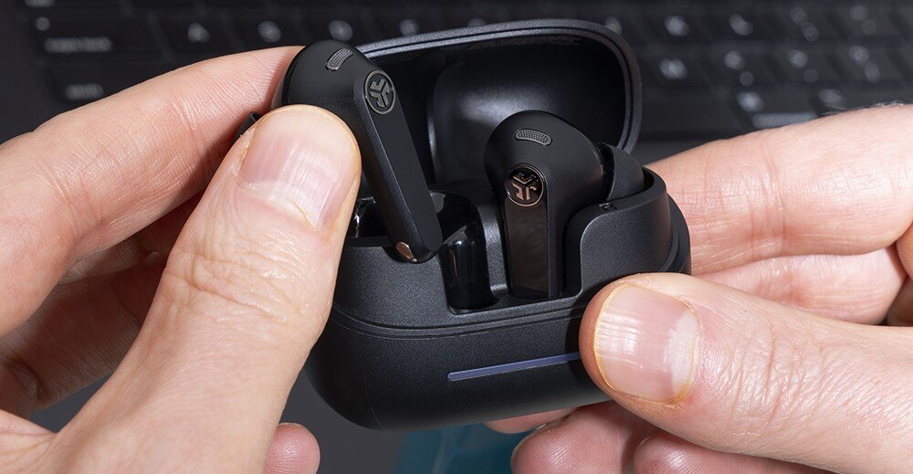 Słuchawki dokanałowe JLAB Jbuds Pods ANC, regulacja głośności, kontrola dźwięku, ręce trzymające etui do ładowania z słuchawkami