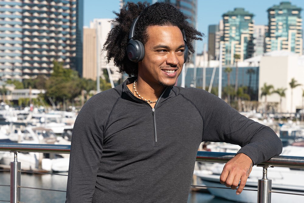 Słuchawki nauszne JLAB GO LUX ANC składane konstrukcja grafitowy kolor wygodny transport, osoba z założonymi słuchawkami na głowie na świeżym powietrzu