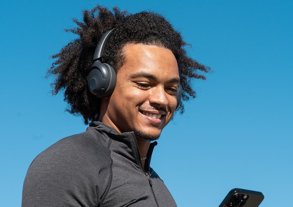 Słuchawki nauszne JLAB GO LUX ANC do telefonów Android i iOS Bluetooth Google Fast Pair ładowanie USB-C, osoba z założonymi słuchawkami na głowie na świeżym powietrzu