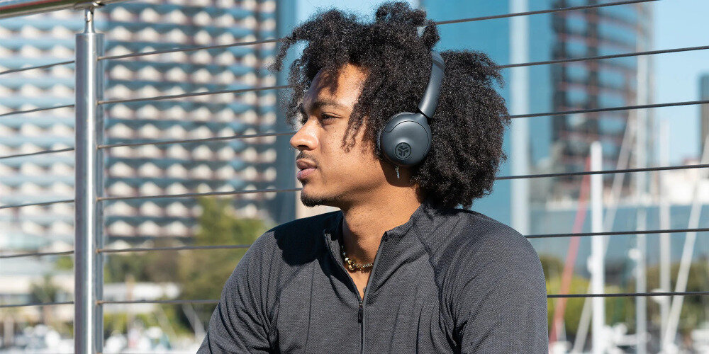 Słuchawki nauszne JLAB GO LUX ANC USB-C Quick Charge ładowanie 2.5 W do 5 W szybkie doładowanie, osoba z założonymi słuchawkami na głowie na świeżym powietrzu