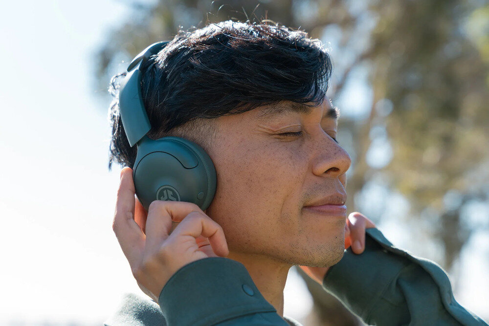 Słuchawki nauszne JLAB GO LUX ANC do codziennego użytku, wygoda, aktywna redukcja szumów, bezprzewodowe Bluetooth, osoba z założonymi słuchawkami na głowie na świeżym powietrzu
