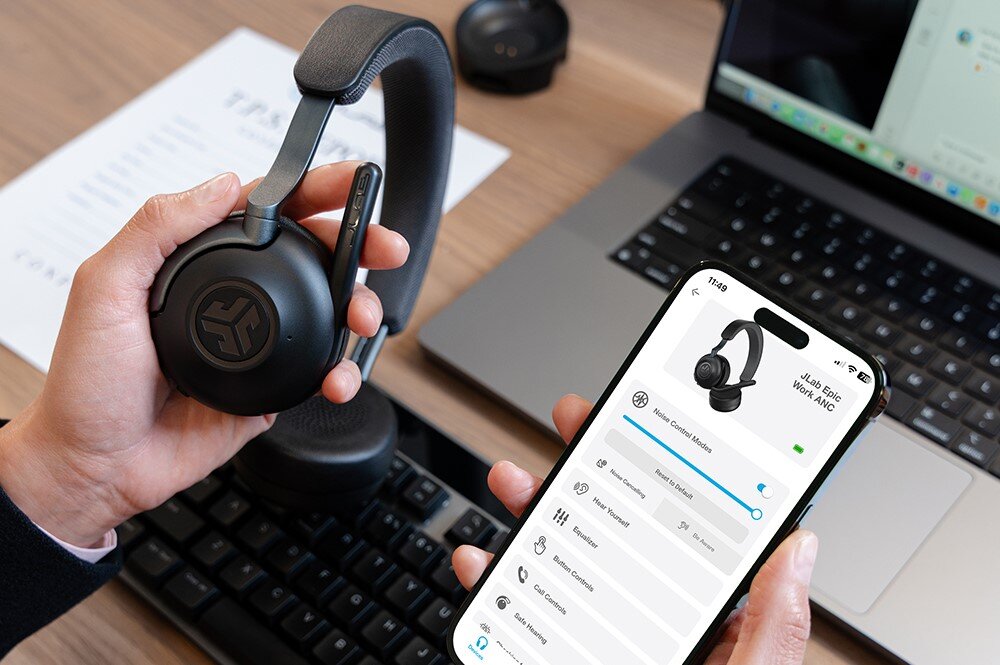 Słuchawki nauszne JLAB Epic Work, dedykowana aplikacja, konfiguracja ANC i ENC, słuchawki trzymane w lewym ręku oraz smartfon z włączoną aplikacją trzymany w prawym ręku
