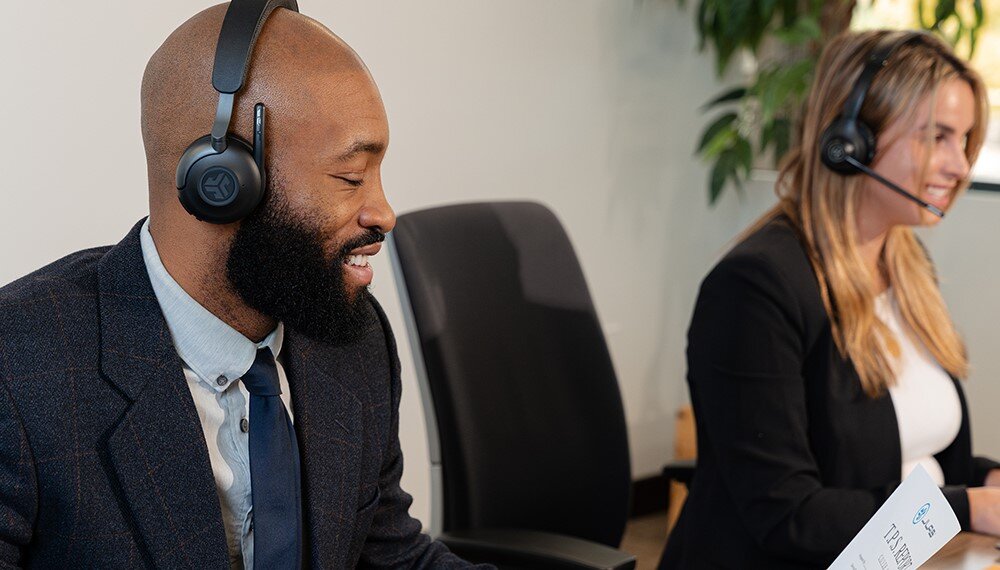 Słuchawki nauszne JLAB Epic Work, ANC, redukcja szumów w pracy i domu, oisoby z założonymi słuchawkami siedzęce przy biurkach