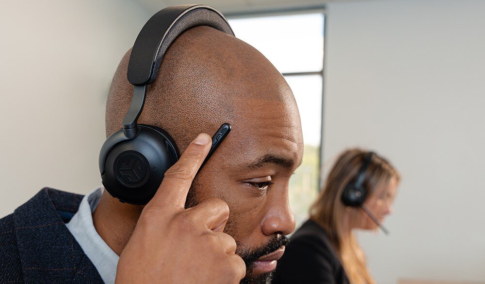Słuchawki nauszne JLAB Epic Work, regulacja głośności, komfort odsłuchu, osoby z założonymi słuchawkami siedzące w biurze