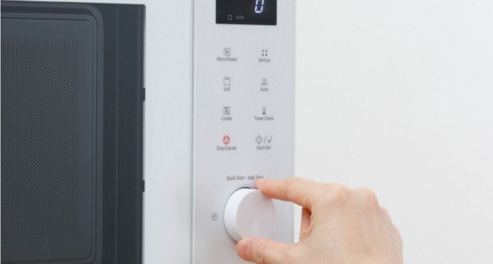 KUCHNIA MIKROFALOWA PANASONIC NN-GD34QWEPG Panel sterowania kuchenki mikrofalowej w białej obudowie; dłoń obraca duże, okrągłe pokrętło „Quick Start / Add Time”, nad którym widoczne są dotykowe przyciski m.in. Micro Power, Grill, Combi oraz Start/Set elegancki minimalistyczny design seria GD kuchnia stal nierdzewna czerń biały wyświetlacz LED intuicyjne pokrętło panel dotykowy łatwa obsługa stylowe AGD codzienny komfort