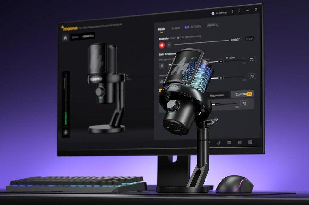 Mikrofon MAONO DM40 Pro Czarny mikrofon z podświetleniem RGB stojący na statywie biurkowym, obok klawiatura i mysz, w tle monitor z programem audio