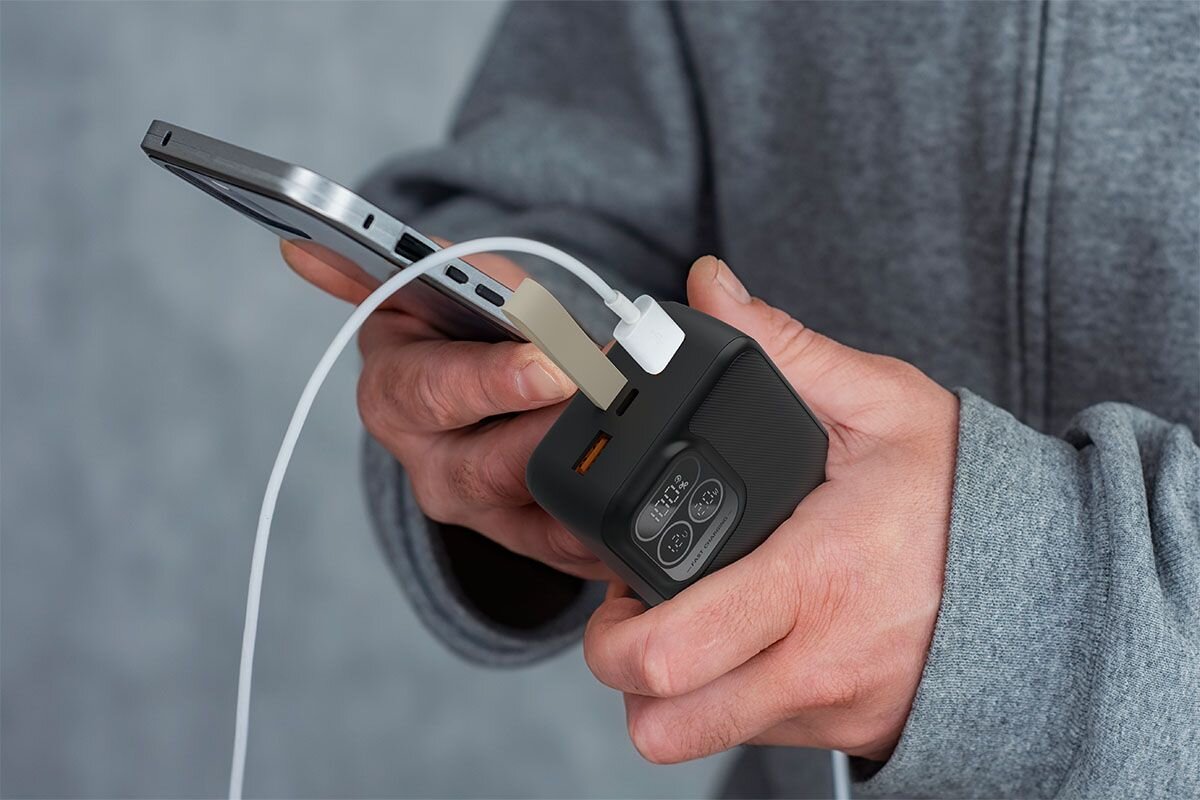 HAWK HW-PB30000 HAWK HW-PB30000 30 000 mAh pojemność umożliwia kilkukrotne ładowanie smartfona, tabletu lub akcesoriów mobilnych Akumulator litowo-polimerowy - powerbank ładujący telefon, trzymany w ręku mężczyny 