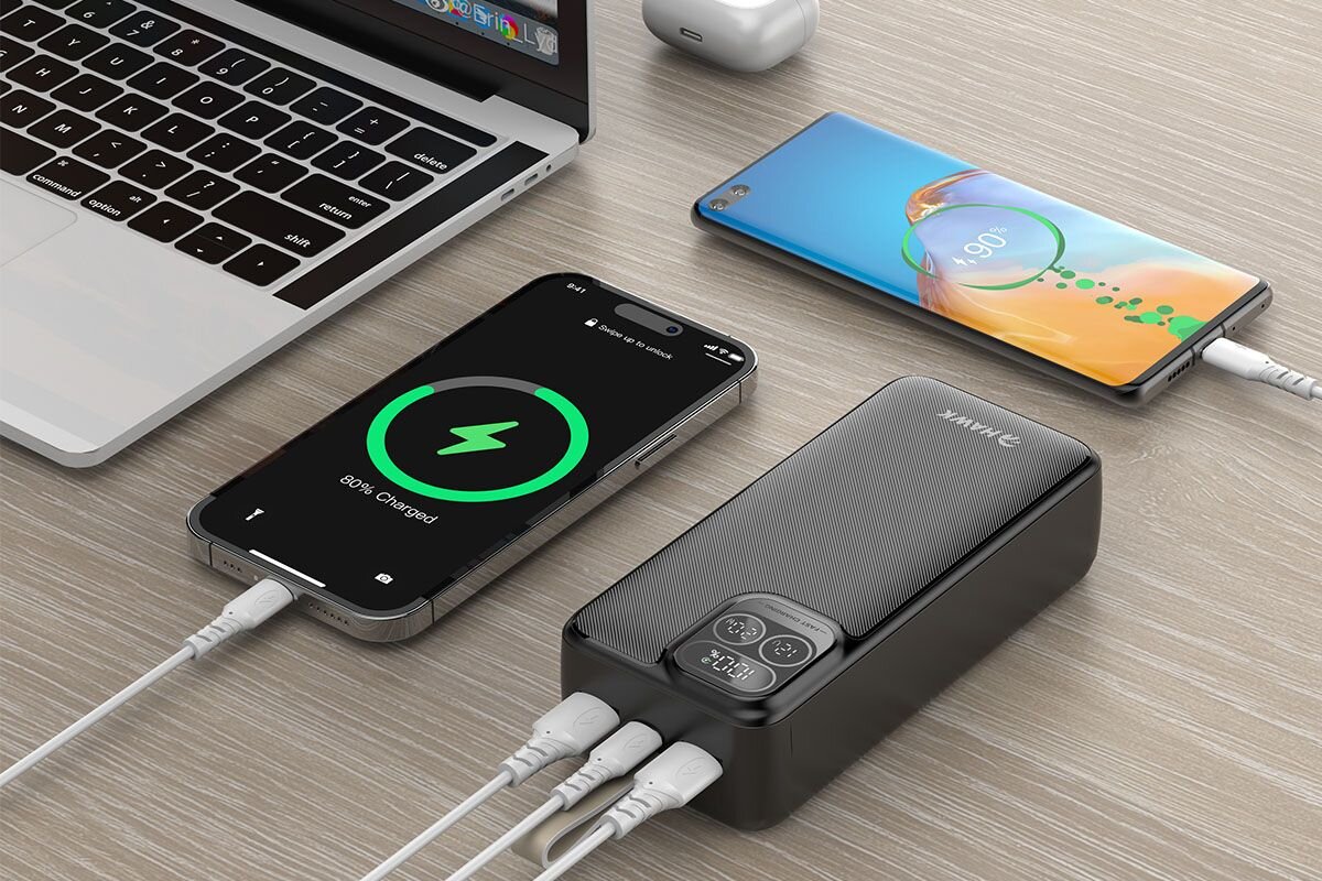HAWK HW-PB30000 Dwa porty USB-A jedno złącze USB-C wejście i wyjście ładowanie do trzech urządzeń jednocześnie pełna moc portu zrównoważony do 15 W - trzy przewody podłączone do powerbankas, obok dwa ładujące się telefony