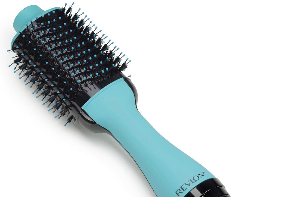 Na obrazie widoczna jest miętowa suszarko-lokówka z czarnymi i niebieskimi włoskami na szczotce. Na uchwycie znajduje się napis \'REVLON\'.