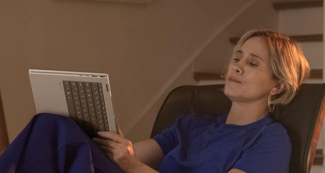 Kobieta korzystająca z laptopa HP OmniBook w trybie tabletu, wygodne użytkowanie na fotelu w salonie. - EPEAT Gold z Climate+ ENERGY STAR       