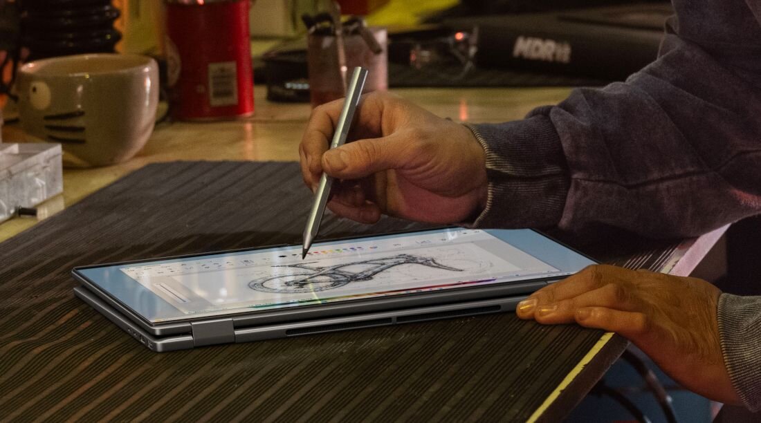 Szkicowanie rysunku roweru za pomocą rysika na laptopie HP OmniBook w trybie tabletu na biurku warsztatowym. - Jakość dźwięku DTS:X Ultra HP Audio Boost