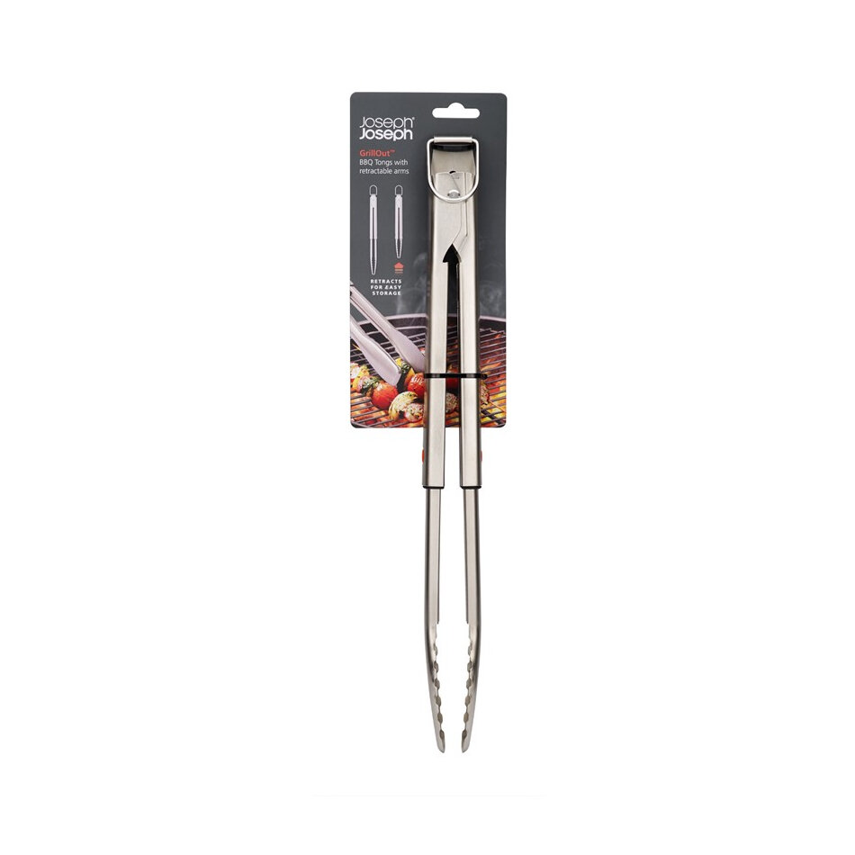 Szczypce do grilla z blokadą są zaprezentowane na tle opakowania z grafiką grillowanych potraw. Na opakowaniu widnieje tekst: \'Joseph Joseph GrillOut BBQ tongs with retractable arms\'.