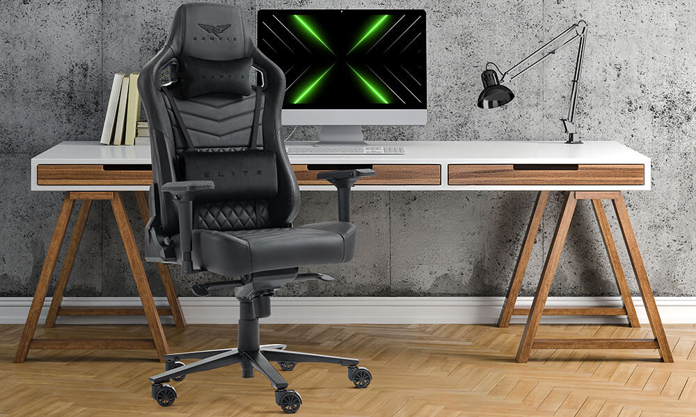 Fotel GAMVIS Elite 2.0 Pro XXL Czarny prezentacja fotela w pokoju przy biurku monitor na biurku szara ściana wielozadaniowość fotel biurowy gamingowy komfort