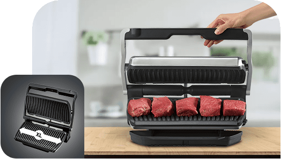 Grill elektryczny z otwartą pokrywą, na dolnej płycie znajduje się pięć kawałków mięsa. W lewym dolnym rogu widoczna jest ikona grilla z napisem \'XL\'.