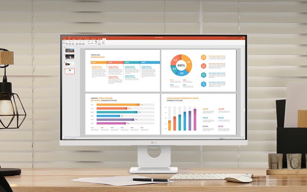 Monitor LG Smart 27U731SA-W.AEU Monitor w jasnej obudowie stojący na drewnianym biurku z otwartym programem do tworzenia prezentacji, na którym widać cztery kolorowe wykresy i infografiki, opis