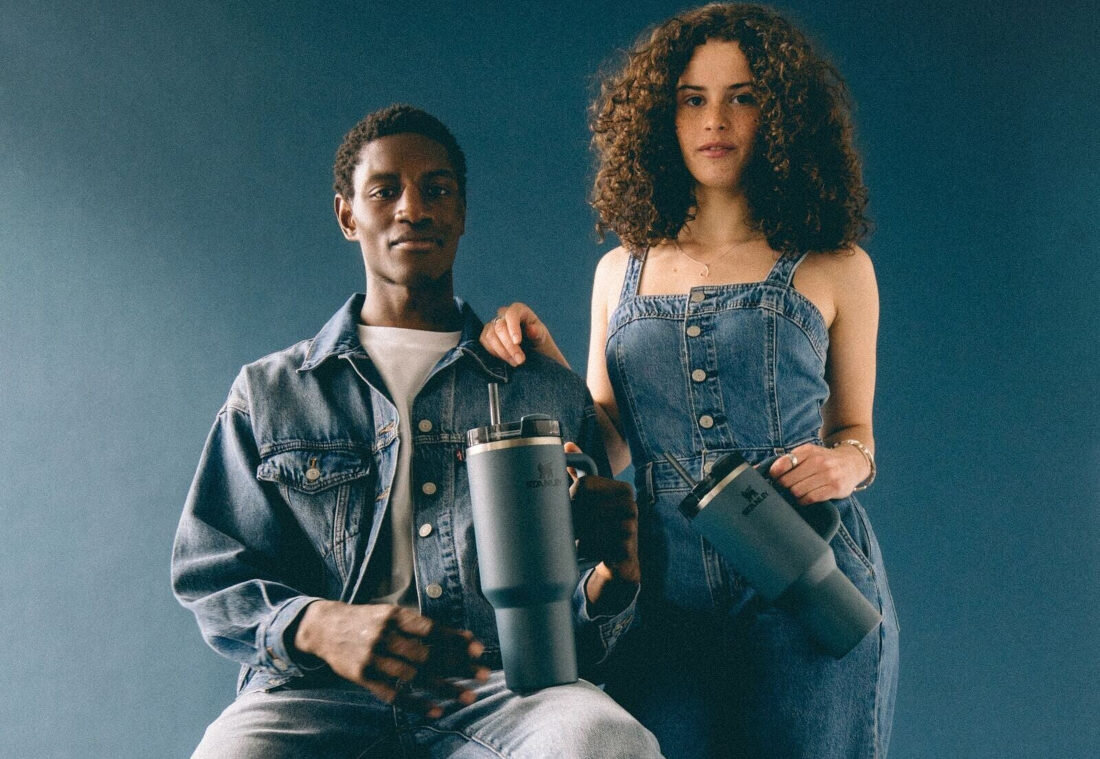 Kubek termiczny STANLEY Quencher H2.0 FlowState Tumbler trzymany w ręce przez uśmiechniętą osobę