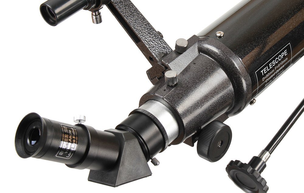 Obraz przedstawia część teleskopu z widocznym okularowym wyciągiem i pokrętłami regulacyjnymi. Na teleskopie znajduje się napis: \'TELESCOPE D:90mm F:910mm\'.