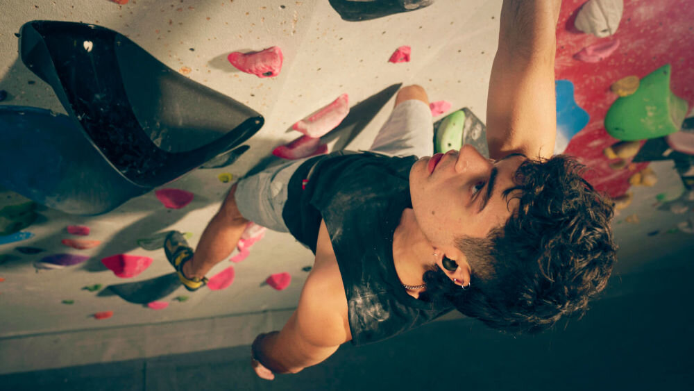 Słuchawki dokanałowe SONY LinkBuds WF-LS910 aktywna redukcja szumów ANC Auto-NC Optimizer dopasowanie, osoba wspinająca się po ściance wspinaczkowej z założonymi słuchawkami