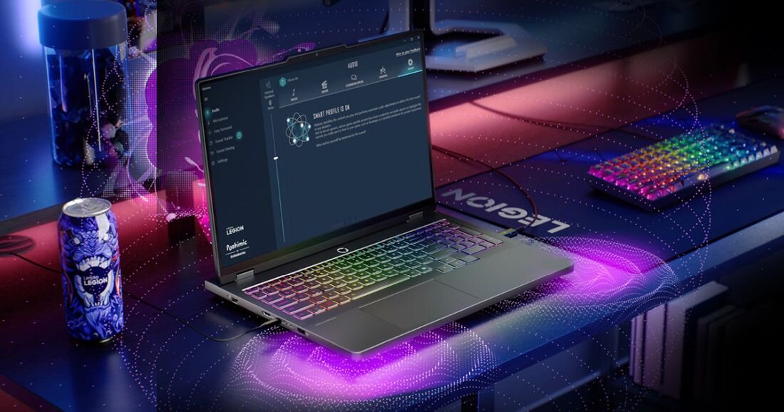  Laptop Lenovo Legion na podkładce gamingowej niebieskiej z napisem Legion, ekran z interfejsem profilu użytkownika Smart Profile z awatarem robota i tekstem profilu gracza, klawiatura RGB podświetlana wielokolorowo fioletowa różowa zielona niebieska na czarnych przyciskach, klawiatura RGB wielokolorowa w tle, komputer gamingowy z RGB po prawej, fioletowo-różowe paski LED pod matą, puszka Legion po lewej, tło niebiesko-fioletowo-różowe - Nahimic by SteelSeries 