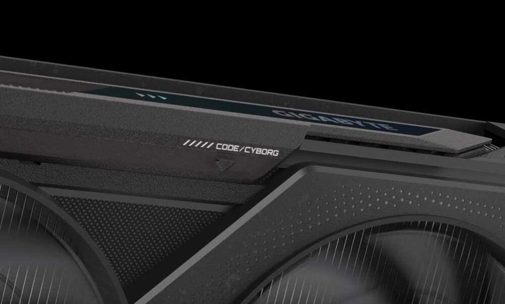 Karta graficzna GIGABYTE GeForce RTX 5050 Gaming OC 8GB Zbliżenie na górną krawędź obudowy karty, widoczne detale faktury oraz mały napis 'CODE/CYBORG' nad wentylatorem