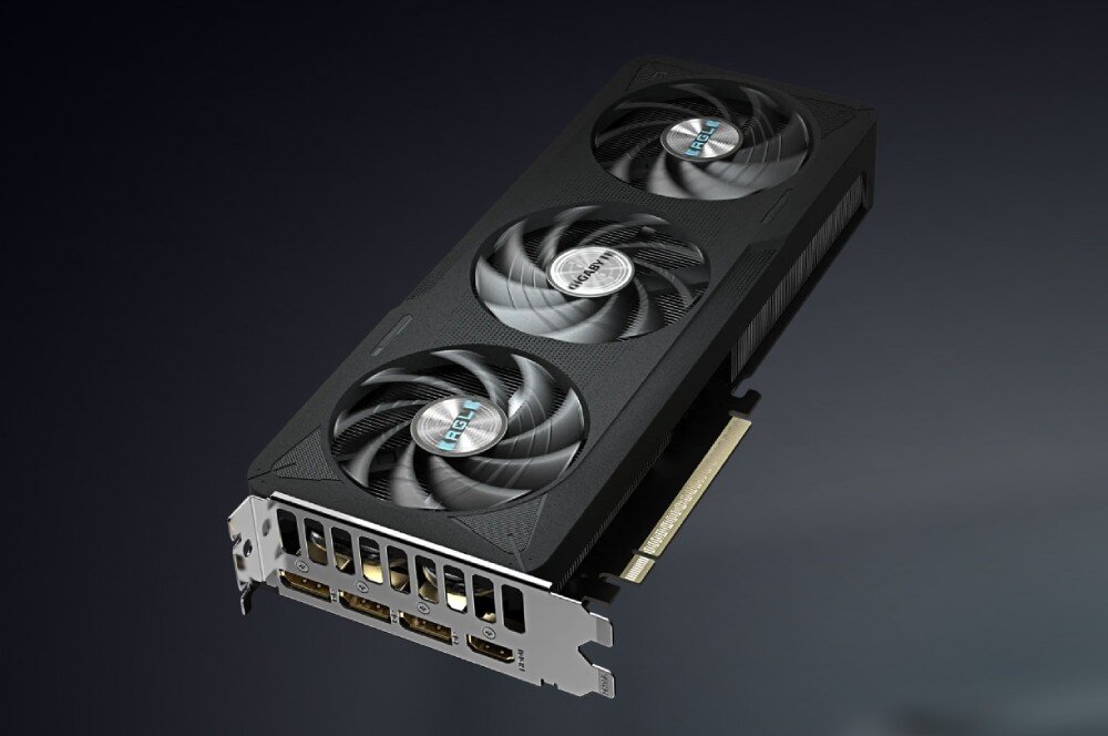 Karta graficzna GIGABYTE GeForce RTX 5060 Eagle Max OC 8GB Karta graficzna widoczna pod kątem na jednolitym tle, prezentująca trzy wentylatory, górną krawędź obudowy oraz złącze PCIe