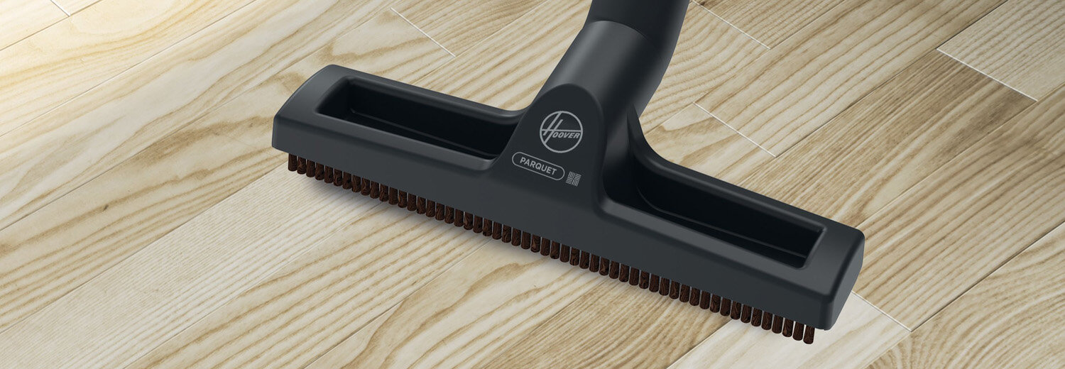 Czarna szczotka odkurzacza z logo \'Hoover\' i napisem \'PARQUET\' znajduje się na drewnianej podłodze.