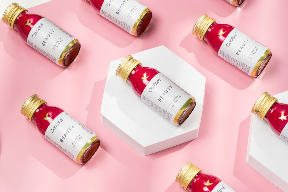 Kolagen COLLIBRE Beauty shot 15 x 60 ml kilka buteleczek ułożoych na podłodze skuteczność przyjemność stosowania o delikatnym brzoskwiniowym smaku gotowe do spożycia poręczna forma jedna buteleczka dziennie