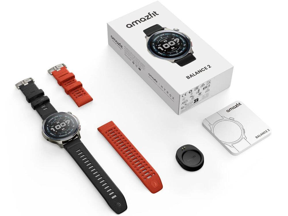 Smartwatch AMAZFIT Balance 2 Czarny Zdjęcie zestawu smartwatcha Amazfit Balance 2 na białym tle, obejmujące: zegarek z czarnym paskiem, dodatkowy czerwony pasek, małą ładowarkę magnetyczną, pudełko z logo Amazfit i nazwą BALANCE 2 oraz instrukcję/kartę z rysunkiem zegarka