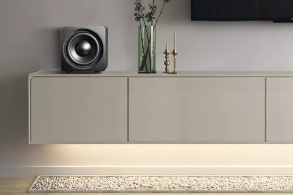 Subwoofer VELODYNE Deep Blue 8 dynamiczne brzmienie niskich tonów precyzyjny bas kompaktowy design, subwoofer stojący na komodzie w pomieszczeniu