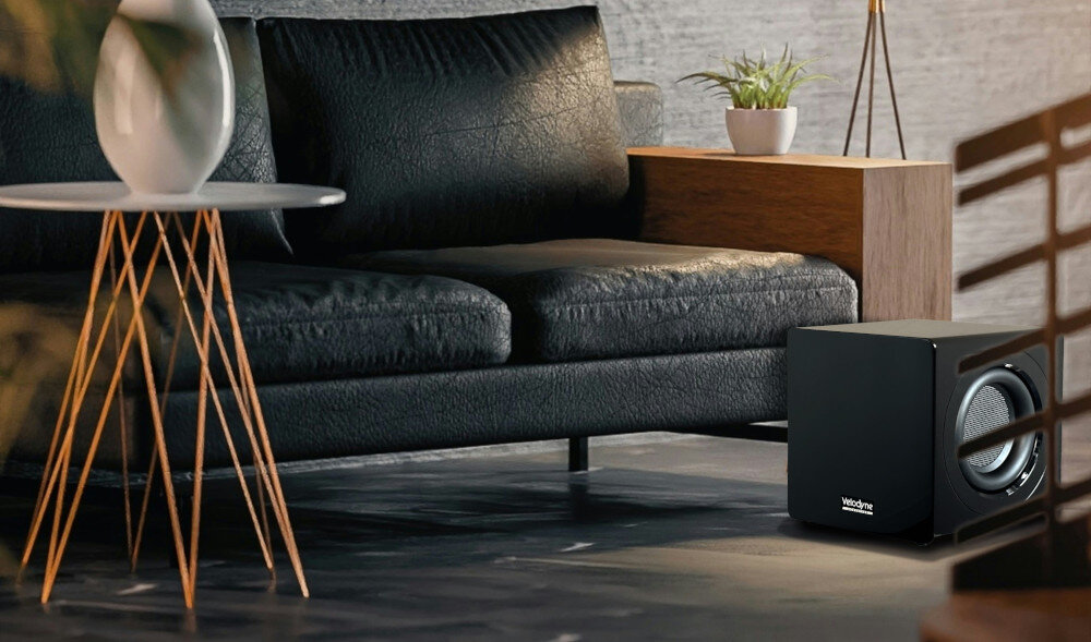 Subwoofer VELODYNE MicroVee X 6.5 cyfrowe sterowanie napędem, subwoofer stojący na podłodze obok kanapy