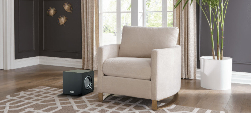 Subwoofer VELODYNE MicroVee X 6.5 obudowa MDF wzmocnienia, subwoofer stojący na podłodze obok fotela