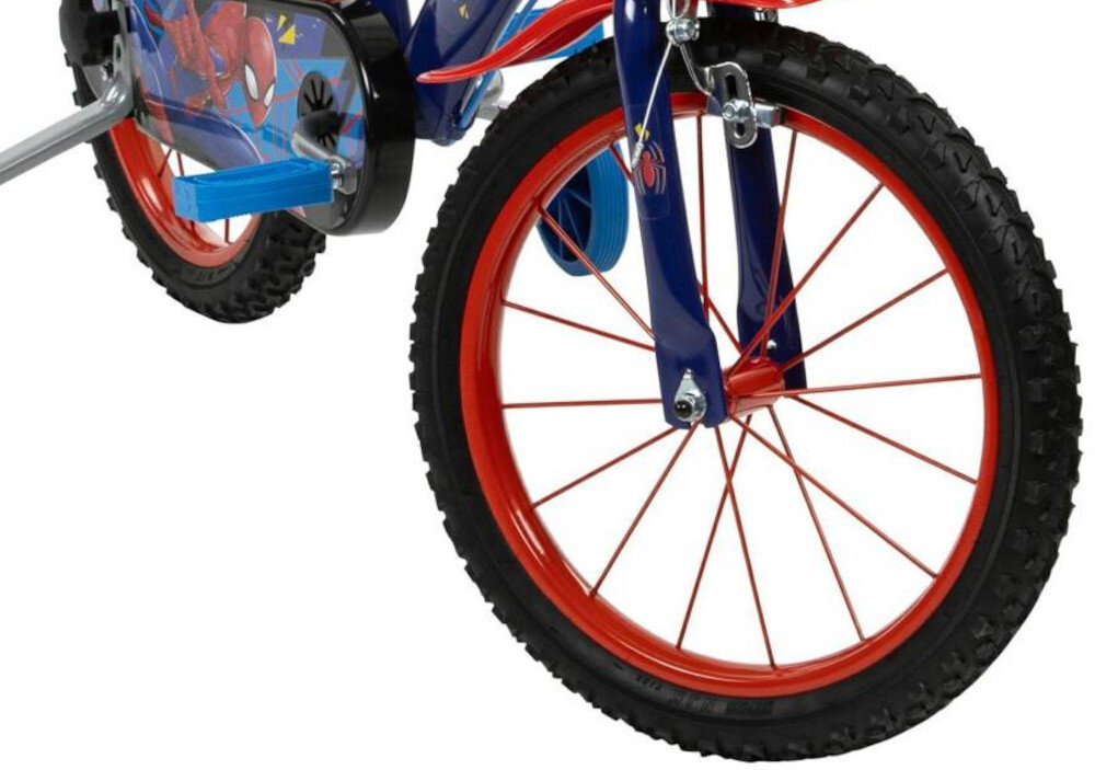 Obraz przedstawia fragment dziecięcego roweru z czerwonymi kołami i niebieską ramą z motywem Spider-Mana. Na osłonie łańcucha widoczna jest grafika z postacią Spider-Mana.