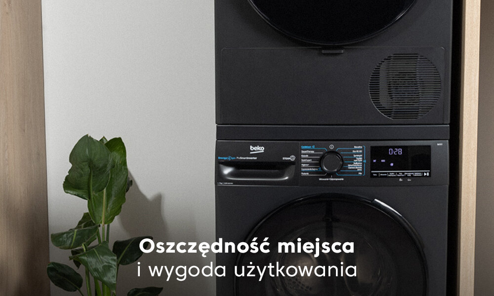 Na obrazie widoczny jest czarny sprzęt AGD marki beko z panelem sterowania i wyświetlaczem. Obok znajduje się roślina doniczkowa, a na dole widoczny jest tekst: \'Oszczędność miejsca i wygoda użytkowania\'.