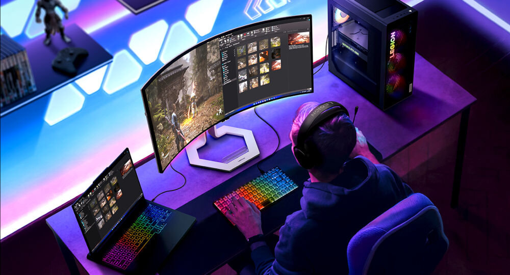 Monitor LENOVO Legion Pro 34WD-10 33.94 cala 3440x1440px OLED 240Hz 0.03 [GTG] Curved prezentacja monitora i podziału ekranu mężczyzna siedzący przy biurku obok laptop i jednostka centralna w gamingowym pokoju True Split podział ekranu KVM PiP PbP wielozadaniowość