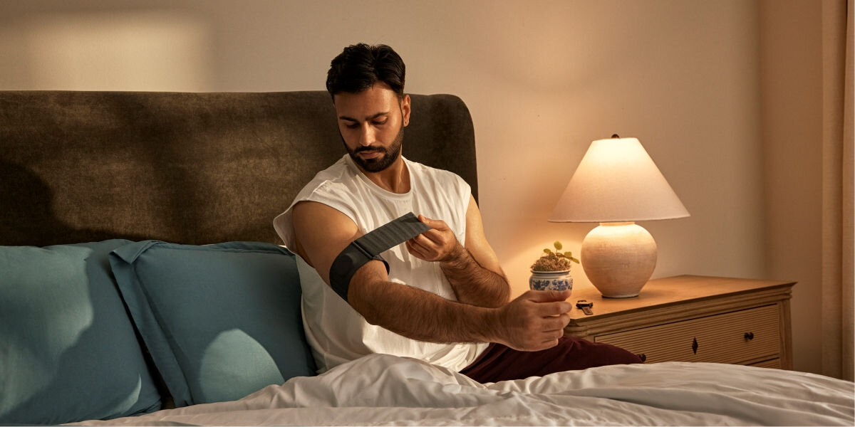 Monitor snu GARMIN Index Sleep (Rozmiar L-XL) Wygodna konstrukcja opaski - osoba zakłądająca opaskę monitor na ramię