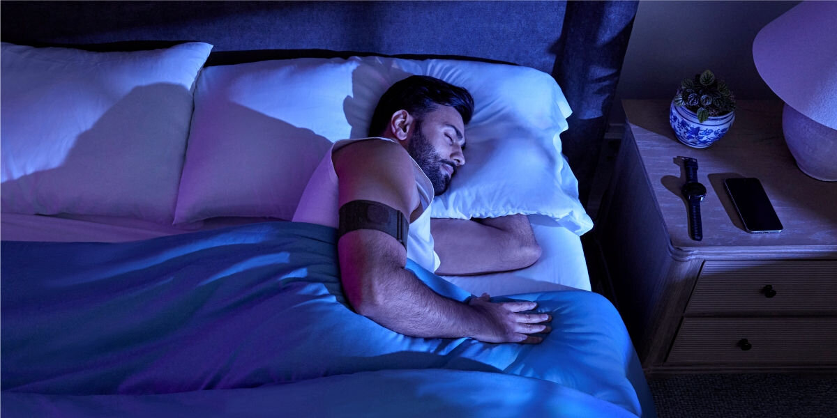 Monitor snu GARMIN Index Sleep (Rozmiar L-XL) Pomiar temperatury skóry - śpiąca osoba z monitorem opaską na ramieniu