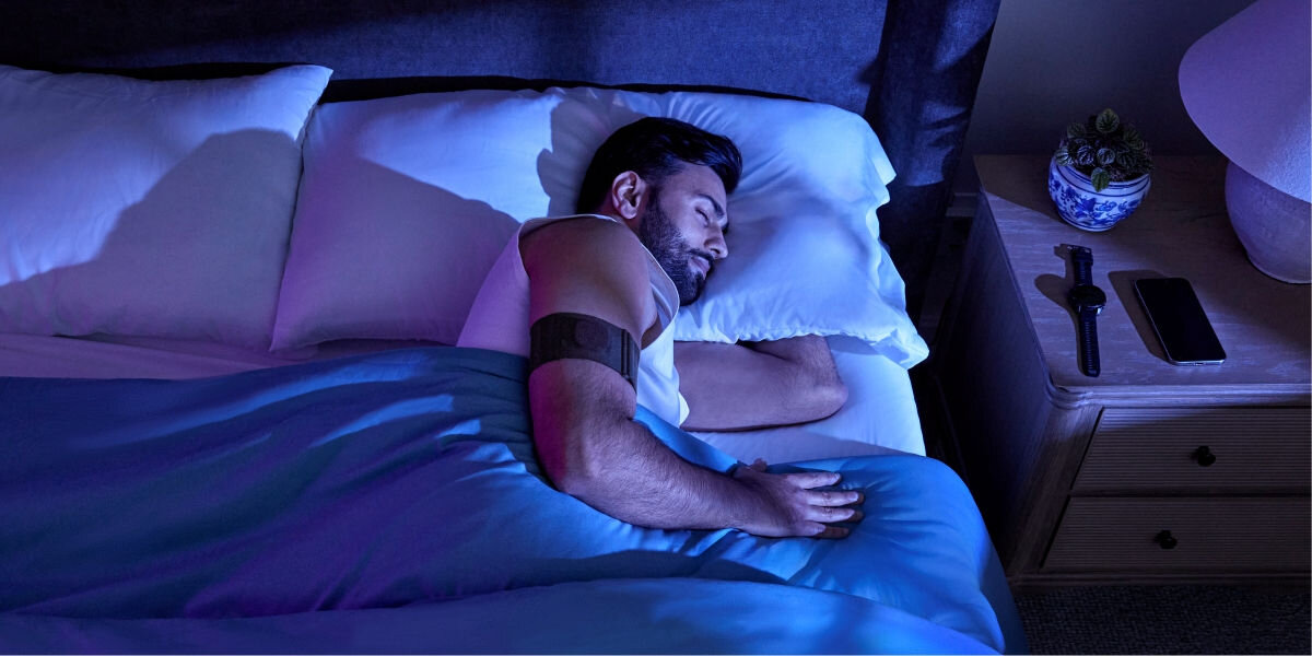 Monitor snu GARMIN Index Sleep (Rozmiar S/M) Pomiar temperatury skóry - śpiąca osoba z monitorem opaską na ramieniu