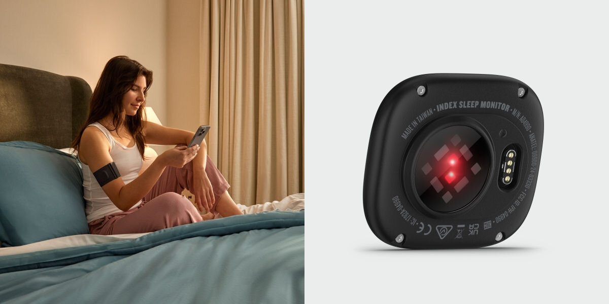 Monitor snu GARMIN Index Sleep (Rozmiar S/M) Inteligentny budzik i HRV - osoba siedząca na łózku z monitorem założonym na ramię i telefonem w ręce