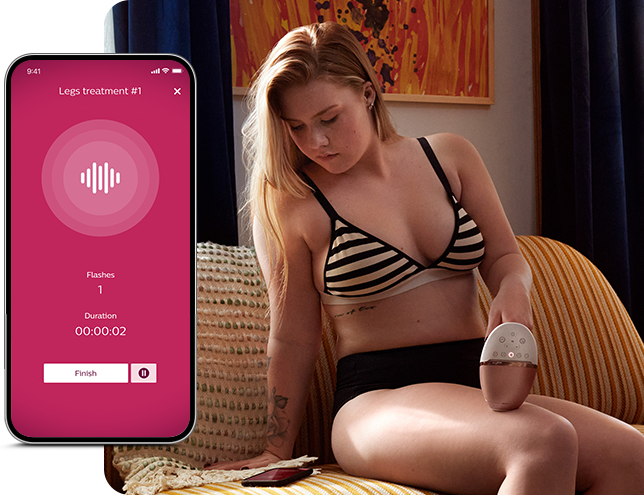Osoba siedzi na kanapie, trzymając w ręku urządzenie przypominające depilator. Obok widoczny jest ekran aplikacji z tekstem: \'Legs treatment #1\', \'Flashes 1\', \'Duration 00:00:02\', oraz przyciskiem \'Finish\'.