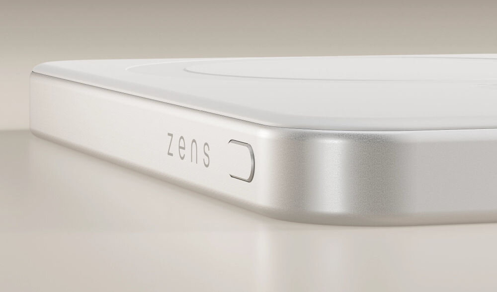 Zbliżenie na biały powerbank z zaokrąglonymi krawędziami, na którym widnieje napis \'zens\'.