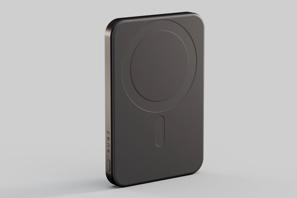 Czarny powerbank o prostokątnym kształcie z zaokrąglonymi krawędziami, z widocznym logo \'zens\' na boku. Na powierzchni znajduje się okrągły wzór oraz podłużny element.